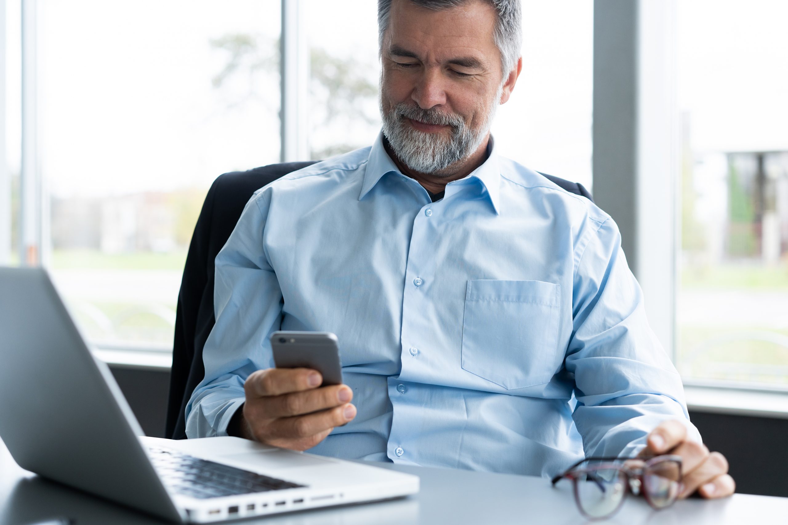 mature-business-man-in-formal-clothing-using-mobile-phone-serious-businessman-using-smartphone-at-work-manager-in-suit-using-cellphone-in-a-modern-office