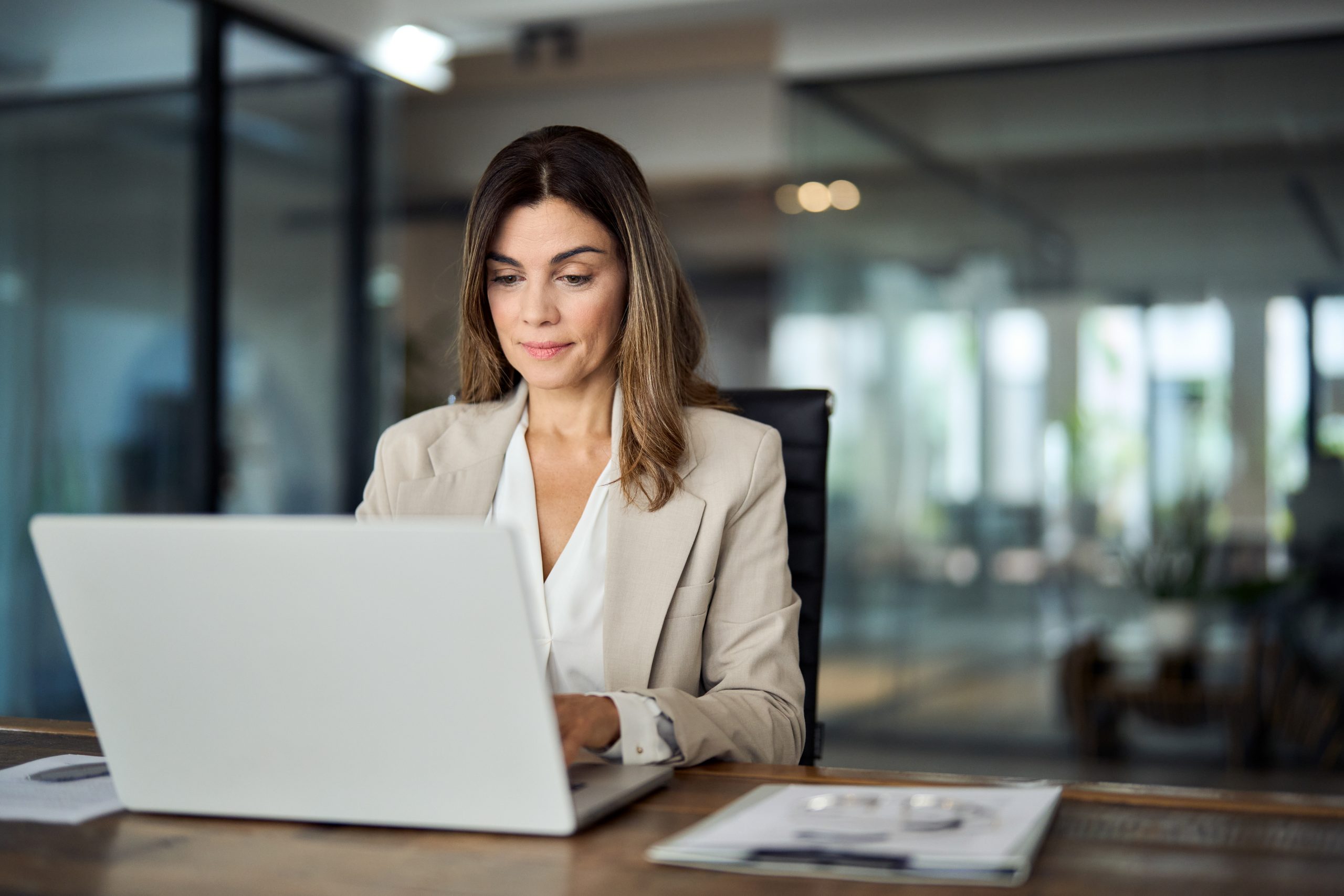 busy-mature-professional-business-woman-looking-at-laptop-working-in-office